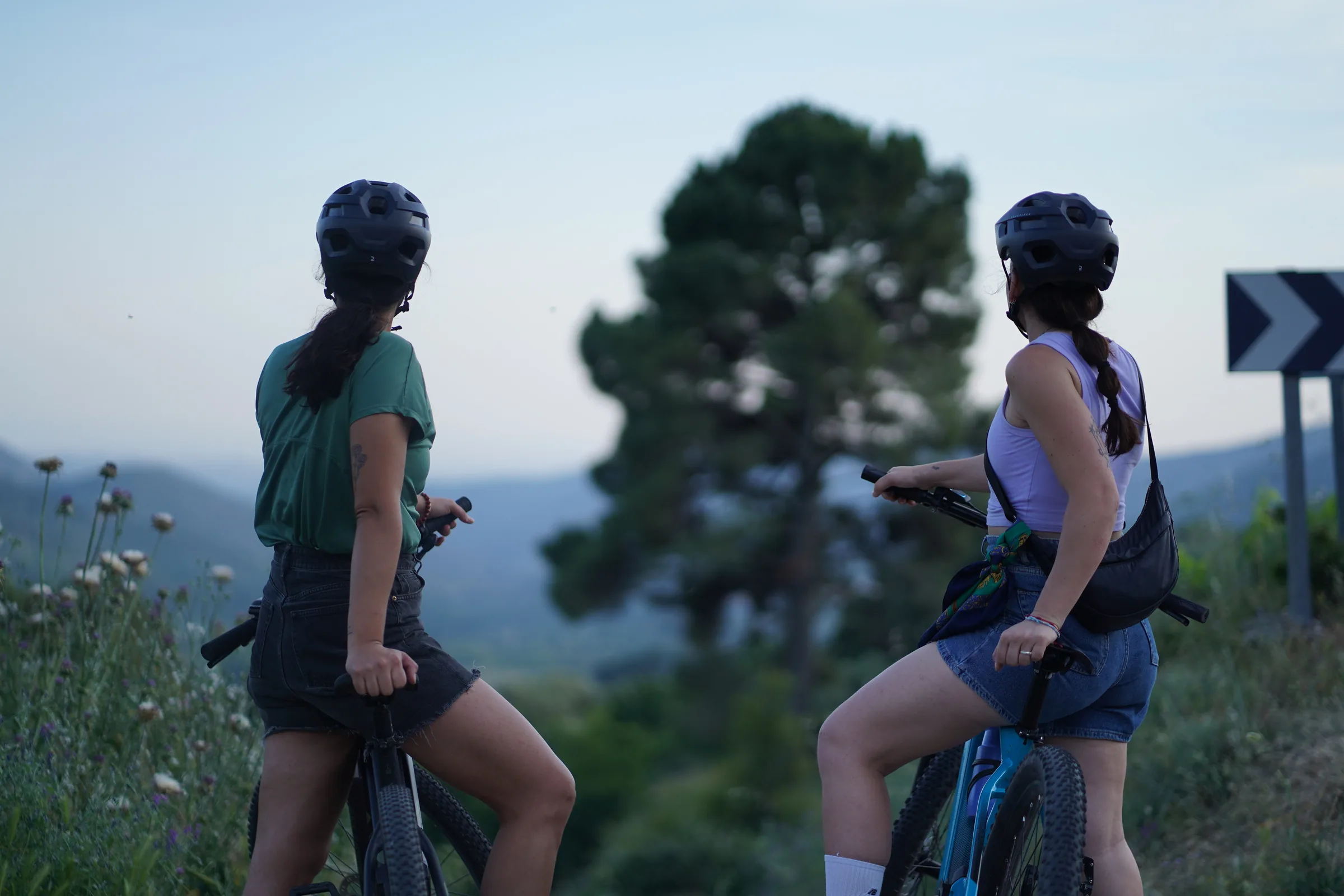 Pareja en bicicletas eléctricas mirando el valle al atardecer